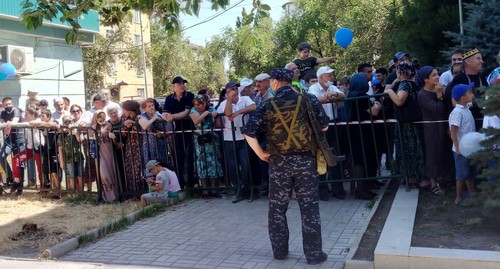 Горожане следят за парадом Победы в Каспийске за ограждением. 24 июня 2020 год. Фото Расула Магомедова для " Кавказского узла"